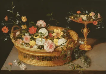 Una canasta de flores con una taza de plata dorada